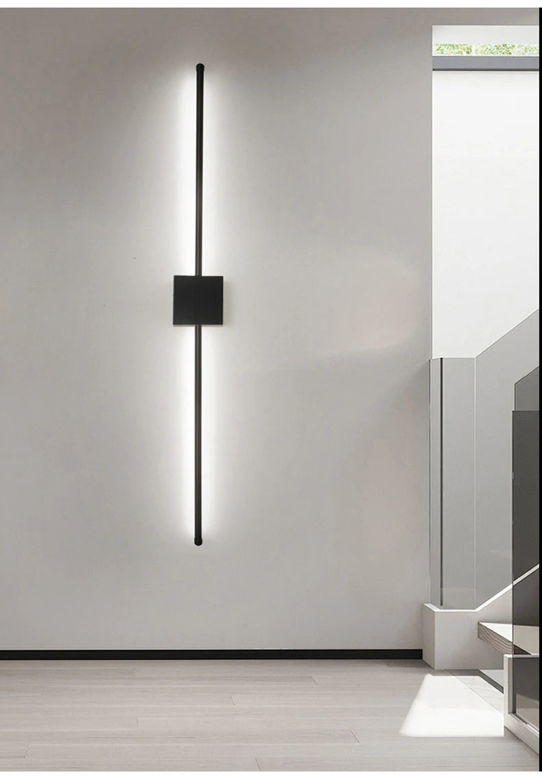 Ambiance minimaliste avec applique murale LED linéaire noire sur mur blanc.