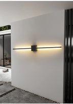 Applique LED linéaire noire installée dans un salon moderne.
