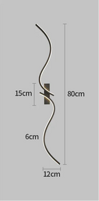 Applique murale LED longue et ondulée en métal noir installée dans un intérieur moderne.